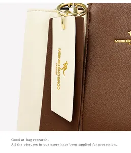 Detail of lychee pattern leather and gold hardware on two-tone tote bag