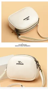 Detail view of the multi-layer zipper design and golden kangaroo logo on the beige leather bag