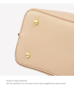 Makroaufnahme von Taschenboden aus apricot Leder mit goldenen Standfüßen und feiner Naht