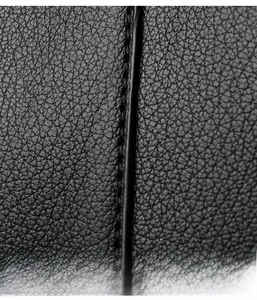 Macro shot of high-quality black litchi pattern leather with precise stitching details