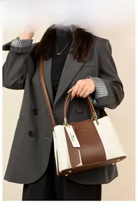 Detailed view of the contrast color leather handbag showing the bottom protective studs
