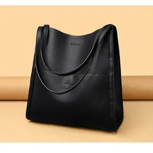 Detail of black lychee grain leather tote bag with embossed kangaroo logo and slim straps