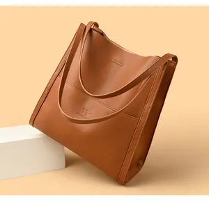 Detailed close-up of brown textured leather tote bag with embossed kangaroo logo