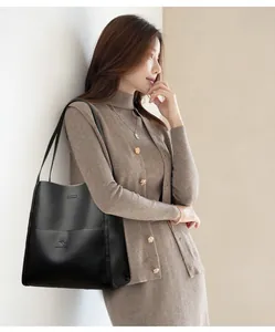 Close-up of black litchi grain leather tote bag with embossed kangaroo logo detail