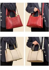 Detailed view of red and beige faux leather handbags with 3D embossed floral patterns
