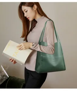 Close-up of a dark green pebble leather tote bag with a kangaroo logo and brand text