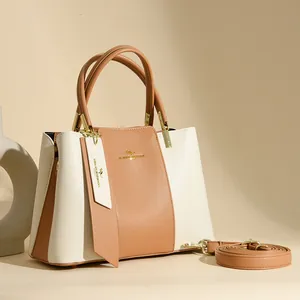 Minimalist beige and brown leather tote bag with gold kangaroo logo and shoulder strap