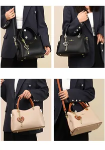 Detail der Luxus-Lederhandtasche mit Litschi-Maserung und goldenem Logo-Beschlag
