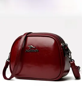 Macro shot of wine red oil wax leather bag with metallic kangaroo logo and dual zippers
