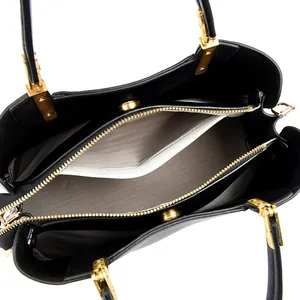 Internal view of a black leather handbag with gold hardware and herringbone lining