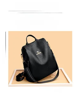 Close-up of black textured leather backpack with golden kangaroo logo and woven strap