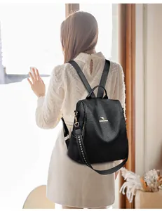 Close-up of black leather backpack featuring golden kangaroo logo and side zipper details