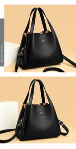 Detail of black lychee grain leather bucket bag with golden hardware and kangaroo logo