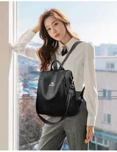 Close-up of black lychee grain leather backpack with golden kangaroo logo and jacquard strap