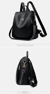 Detail view of black lychee leather backpack with golden kangaroo logo and metal zippers