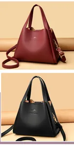 Detailed view of leather bucket bags in burgundy and black with kangaroo embossed logo