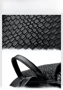 Detail of woven texture black leather and reinforced stitching on the handbag handle