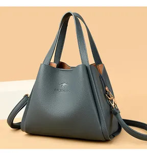 Detail of the litchi grain leather texture and golden hardware on the dark grey bucket bag