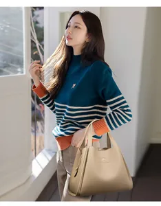 Detail of high-quality cream white leather bucket bag with brand logo and gold zipper