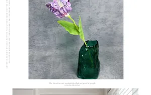 Détail d'une tulipe artificielle violette texturée dans un vase en verre vert foncé