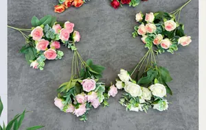 Flat lay of realistic 10-head faux rose bouquet with layered petals and green leaves