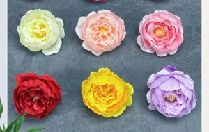 Flat lay of realistic artificial peony heads in six colors for DIY wedding decor