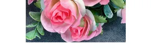 Close-up of pink artificial roses with silk petals and green leaves for home decor