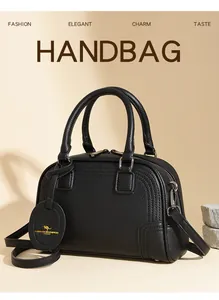 Detail of black lychee grain leather Boston bag with kangaroo logo and shoulder strap