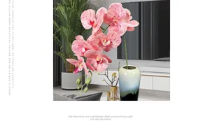 Roze gevlekte kunstmatige orchidee in blauwe keramische vaas voor huisdecor