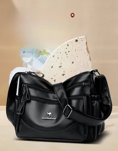 Close-up of black litchi texture leather handbag with triple silver zipper pockets