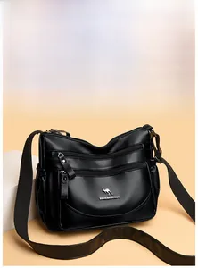 Detail of black pebbled leather handbag with metal zippers and kangaroo brand logo