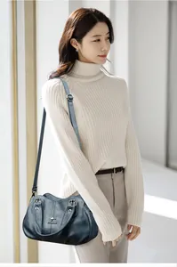 Detail view of leather texture and kangaroo metal logo on a stylish blue crossbody handbag