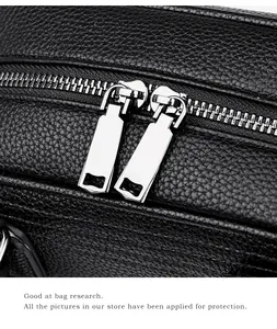 Macro detail of high-quality black litchi leather texture with dual silver metal zippers