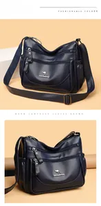 Detailed macro view of dark blue litchi leather bag with multi-zipper compartments