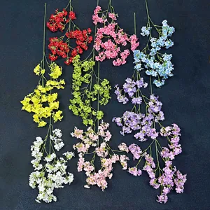 Artificial babys breath flowers in various vibrant colors on a dark textured background