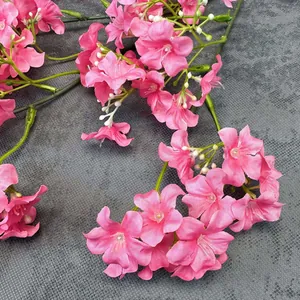 Lifelike pink silk flowers with white stamens on grey background for home decoration
