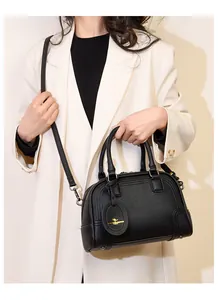 Close-up of black lychee grain leather Boston bag with gold kangaroo logo and metal feet
