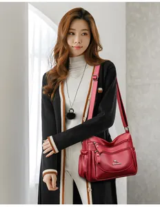 Detail view of burgundy leather shoulder bag with multiple zippers and kangaroo logo