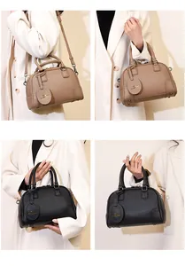 Detail of Boston bags in khaki and black pebbled leather with adjustable straps