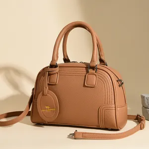 Classic tan pebble leather Boston bag with top handles and adjustable shoulder strap