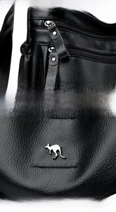 Macro shot of black lychee grain leather, silver Kangaroo logo and metal zippers