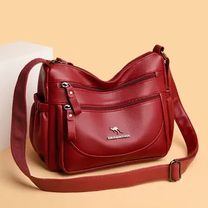 Burgundy faux leather crossbody bag with multiple zippers and adjustable shoulder strap