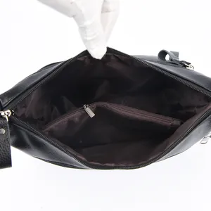 Internal view of black lychee leather handbag featuring camel pattern lining and compartments
