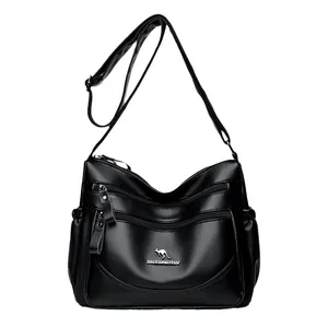Black pebbled leather shoulder bag with multiple zippers and adjustable strap