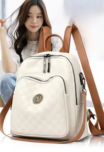 Détail de la poche gaufrée à carreaux sur sac à dos en cuir blanc cassé et marron
