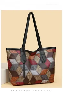 Detail of color-block tote bag showing lychee grain leather texture and handle attachment