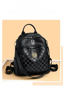 Gros plan du sac à dos noir à damier avec logo doré et texture en cuir de haute qualité