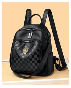 Vue latérale du sac à dos en cuir noir avec motif à damier et emblème métallique rond