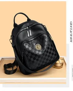 Détail d'un sac à dos en cuir noir avec texture à damier et emblème circulaire doré