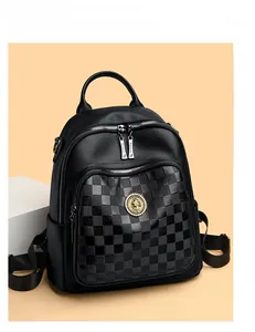 Détail d'un sac à dos noir en cuir grainé avec poche en damier et emblème doré